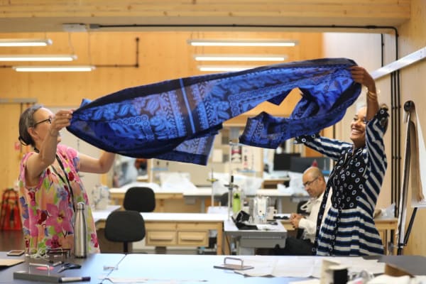 Two women floating a scarf at a workshop. 