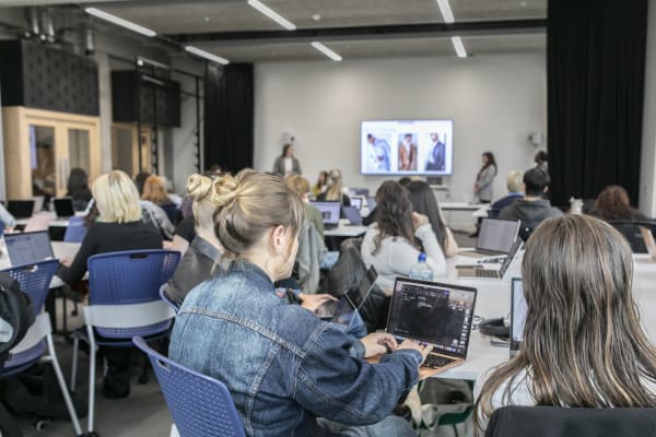 People sat in a classroom with laptops on tables