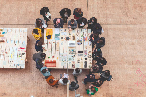 Top down view of students gathered around a table looking at items