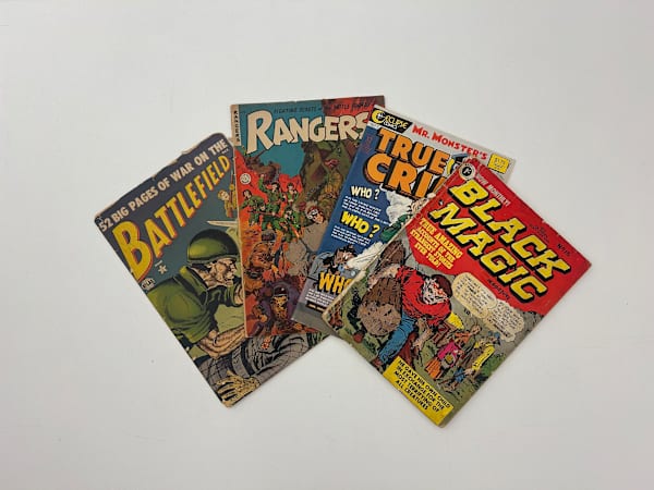 Colour photograph of comics from the 1950s, titled, 'Black Magic,' 'True Crime,' 'Rangers' and 'Battlefield'. 