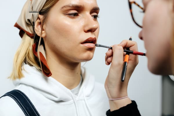 Woman putting make-up on a model