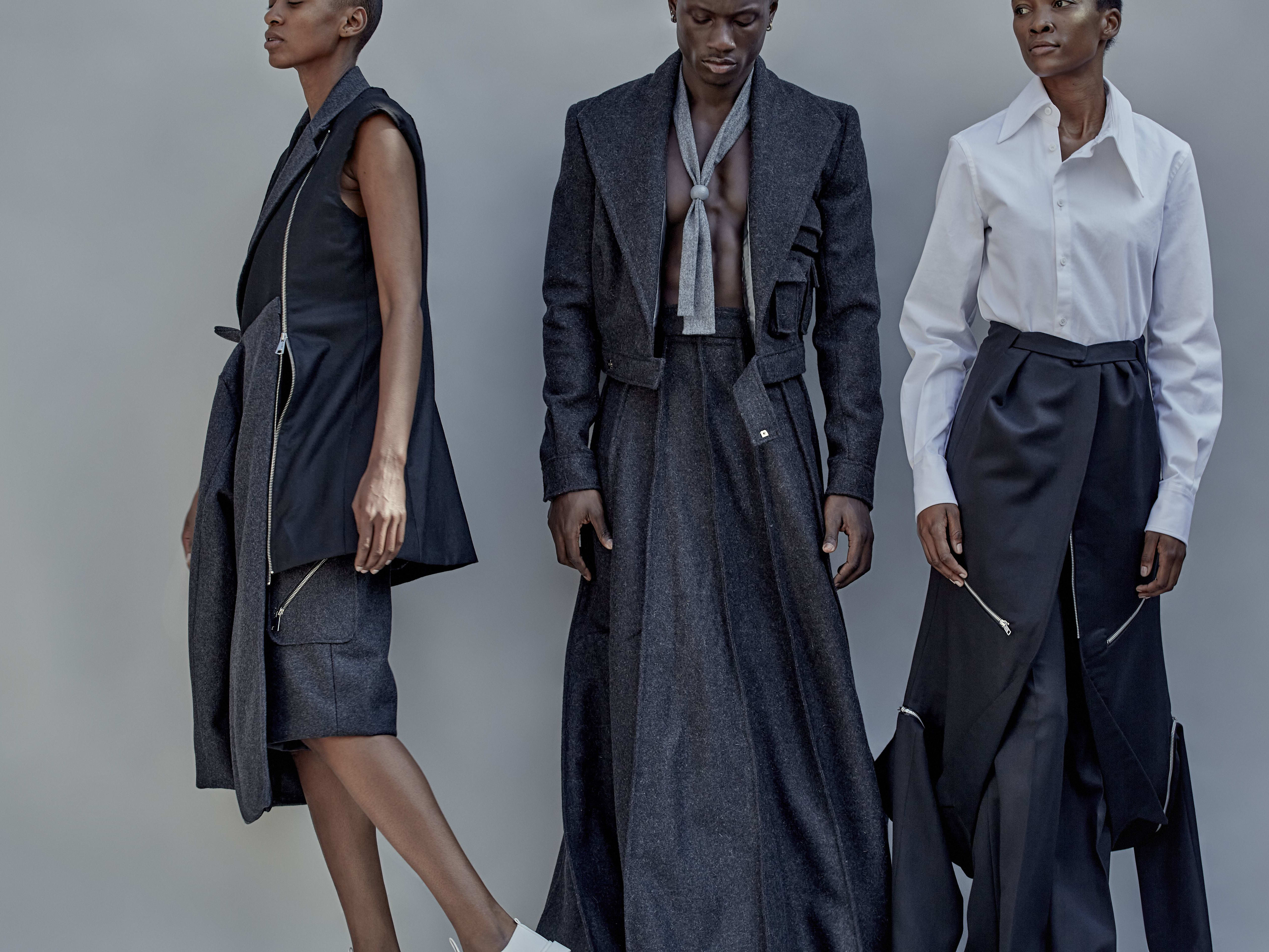 Three models in a variety of navy tailored clothing.