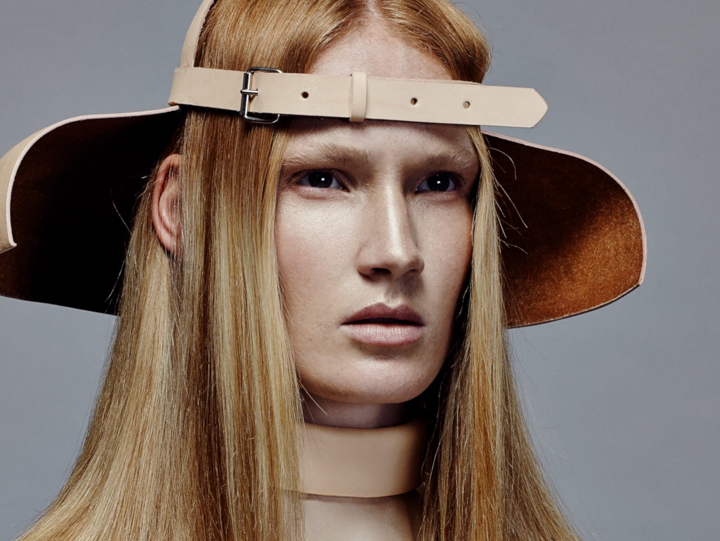 Female model in hat with glossy strawberry blonde hair.