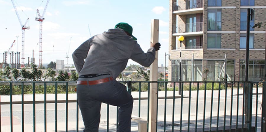 Man climbing over a fence