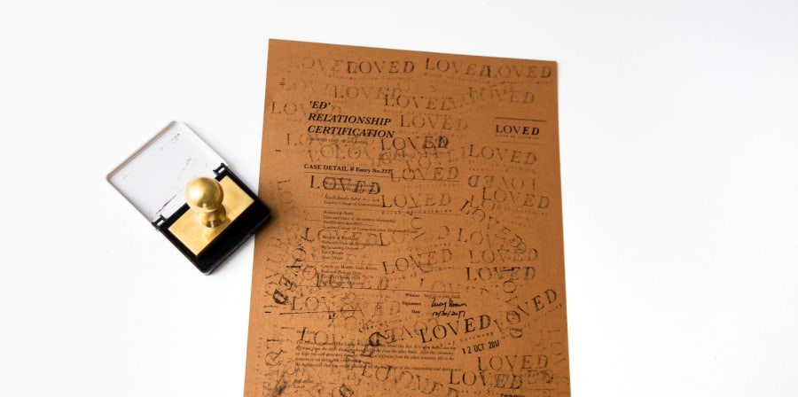 Paper with the word 'Loved' stamped across it multiple times