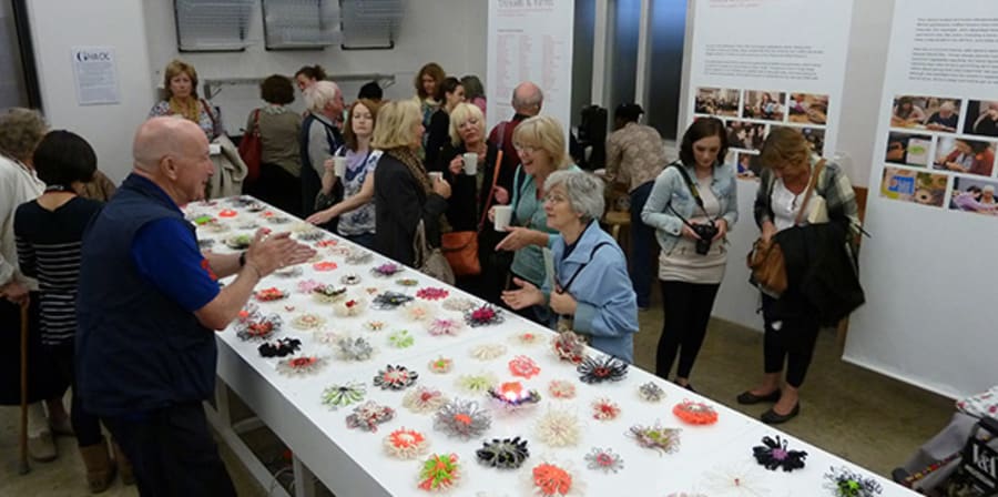 Group of people looking at art displayed on a table
