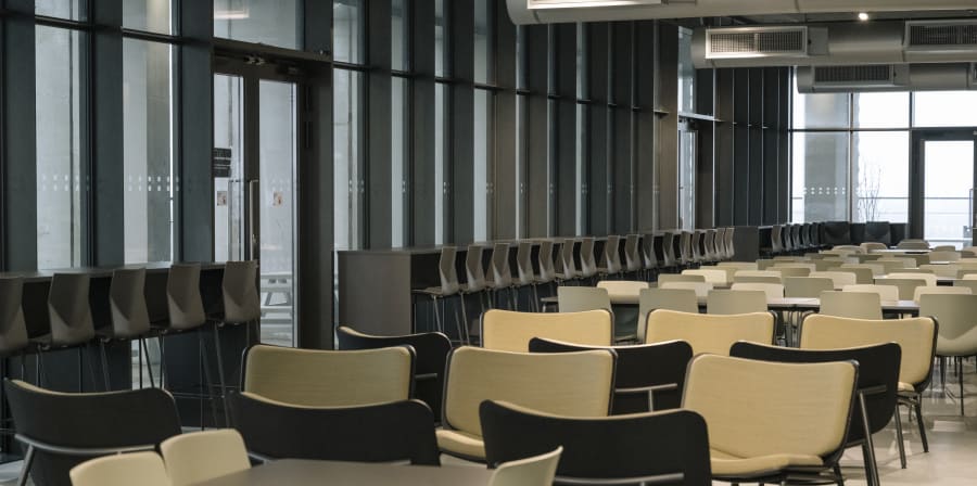 Tables and chairs in a large room with long windows
