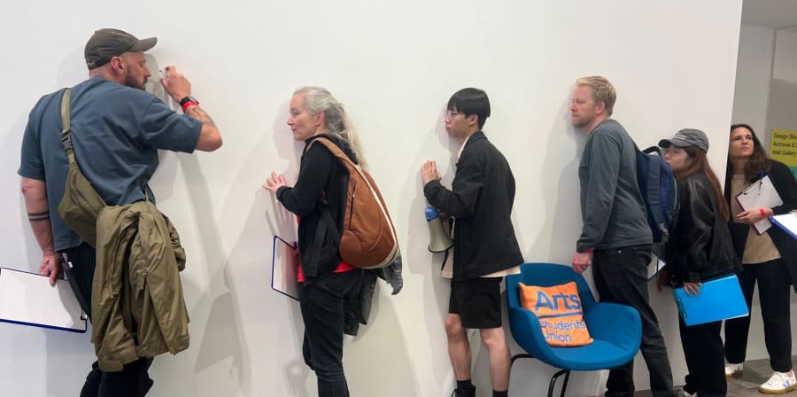 6 people listening to a wall sounds in a workshop activity.