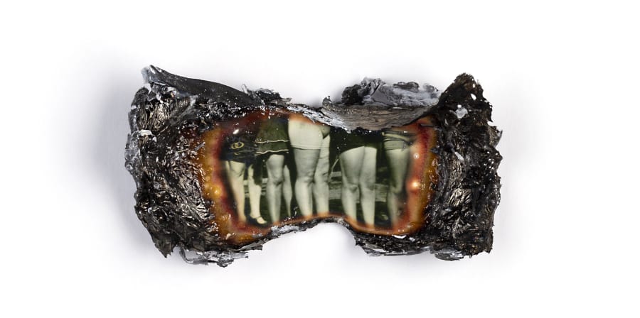 Image of burnt photograph showing only the legs of children.
