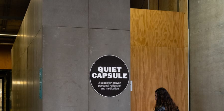 A black circular sign fastened to a wall that reads 