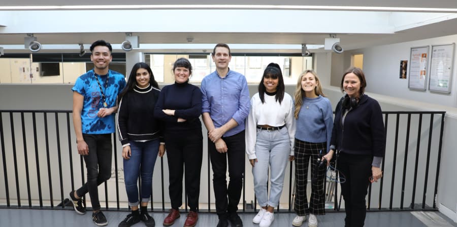Posed group photo of Bruce Daisley with BBC producer and LCC students smiling at camera