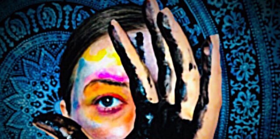 Image of a hand in front of a colourful face, with a blue mandala backdrop