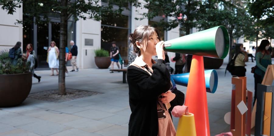 Woman speaking through a mega phone which was part of an exhibit for the Google project