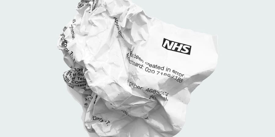 a crumpled up piece of paper with the nhs logo on it