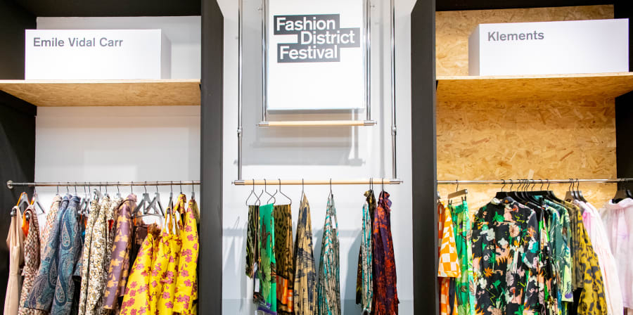 Image of inside of a fashion store with garments in the rails
