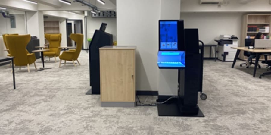 Library space at High Holborn with self issue kiosk, yellow comfortable chairs and tables, desk and bookcase
