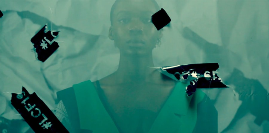A model stands behind green film.