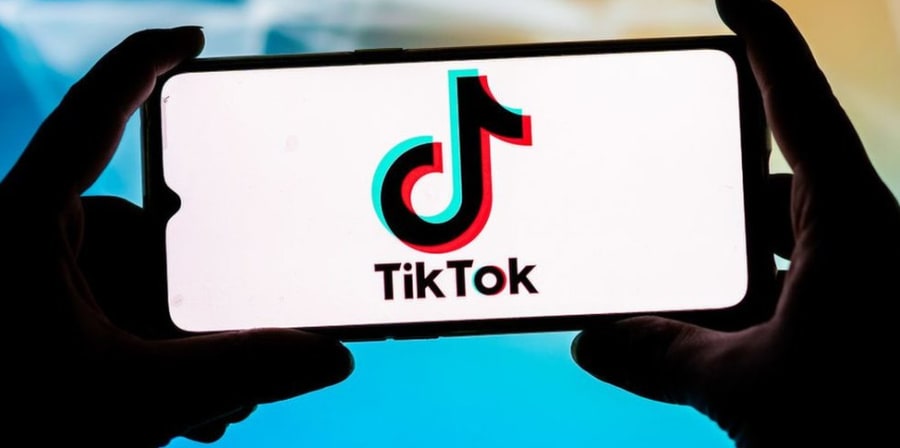 hands holding a phont with tiktok logo on it