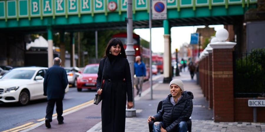 Nicle walking in street with a male wheelchair user