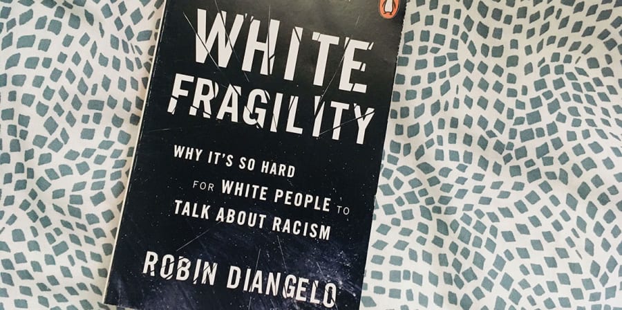 Image depicts White Fragility on a black and white spotted background.