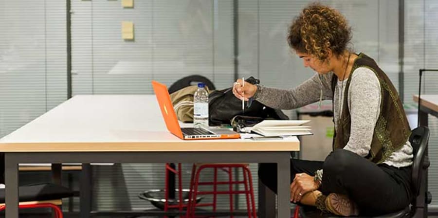 Research student at a desk with books