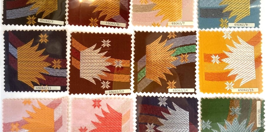 Three rows of four square fabric swatches sit in front of a white background. The swatches are bright and colourful earthy tones mostly of brown, orange, cream, green, yellow and pink.