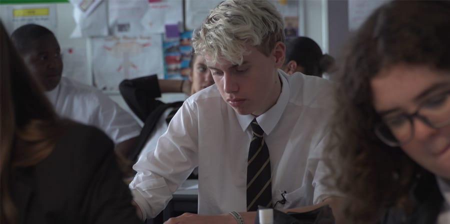 A boy stares at his school desk.