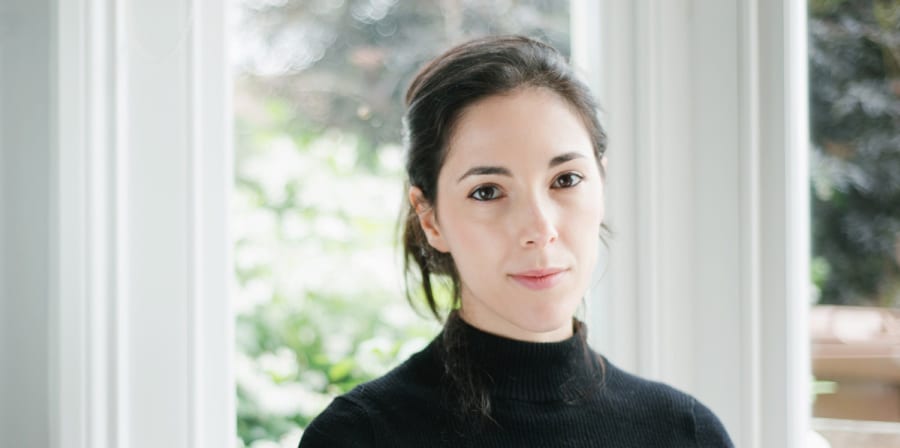 Portrait of Chiara, who has fair skin and black hair, wearing a black turtleneck