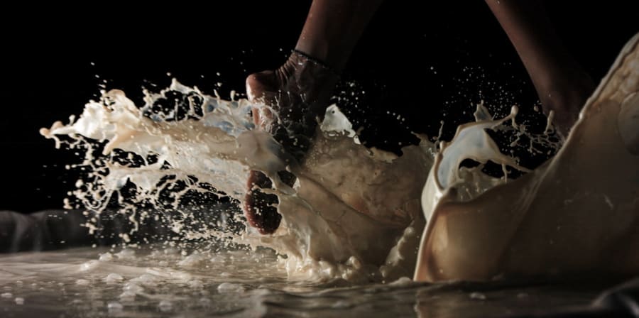 A still from a film showing feet dancing in milk