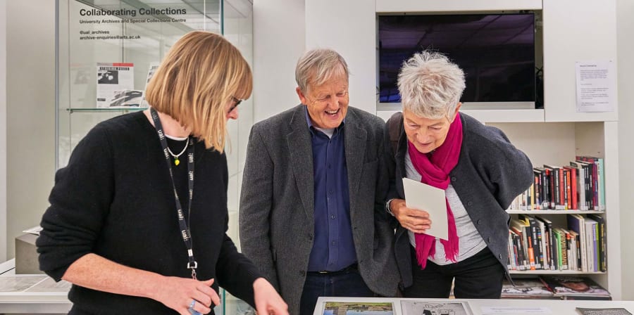 Young woman with two older people looking at archive material