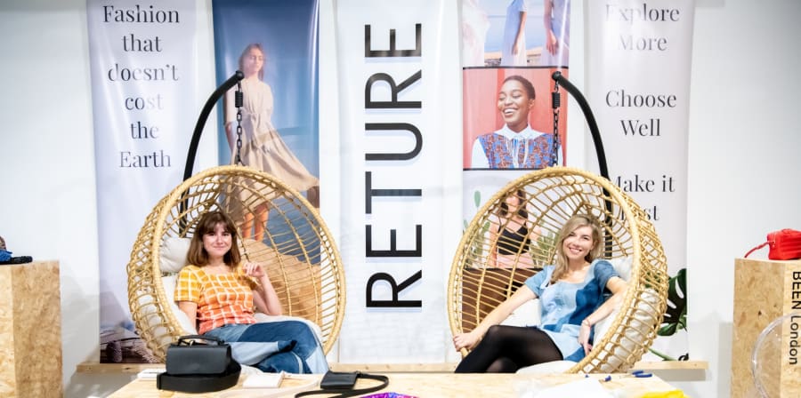 Two women sitting in wicket rockers at a pop-up shop event.