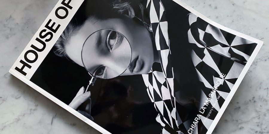 A magazine cover featuring a woman in a black and white-check clothes.