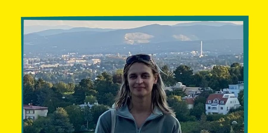 Global Ambassador Isobel on her global experience, standing in fields with a view of city behind her. Surrounded by yellow and green border.