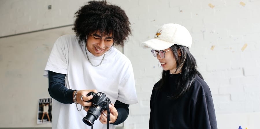 two students looking at a camera screen