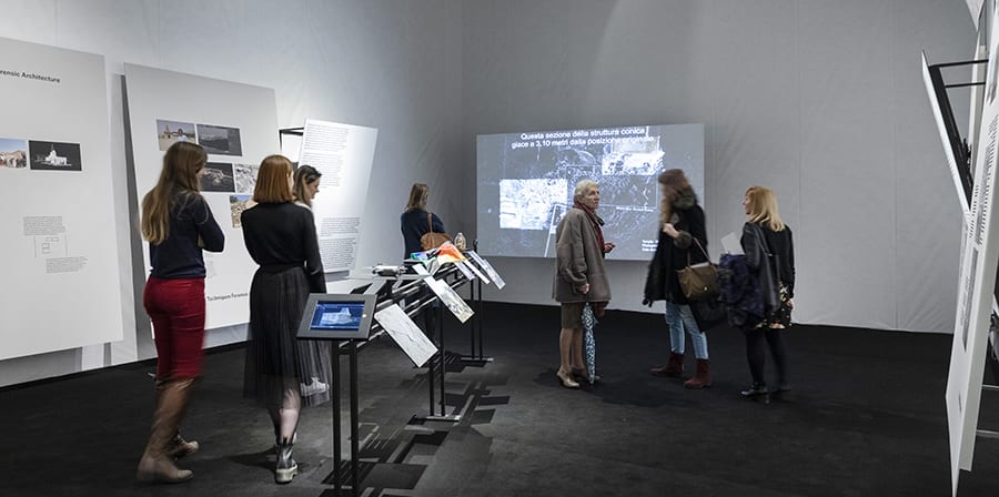 Photo of Maps of Defiance exhibition with visitors and panels. 
