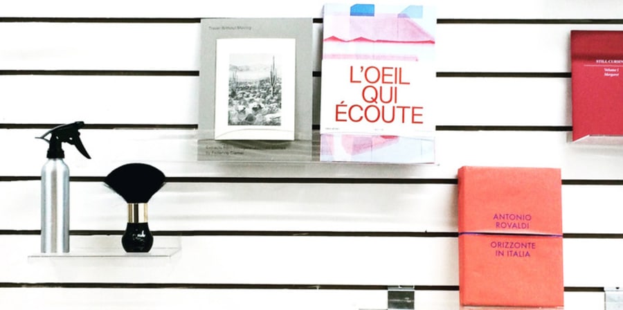 Items are placed on shelves in front of a black and white striped wall.