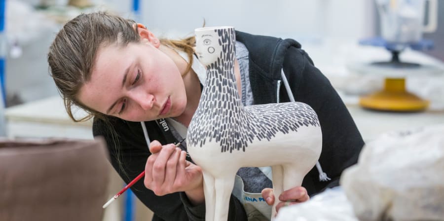 Student working on ceramics design in a workshop space