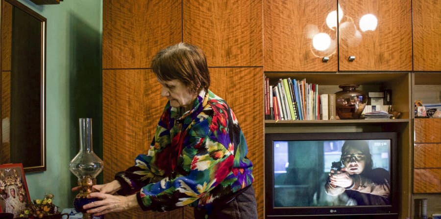 A grandmother stands in her living room.
