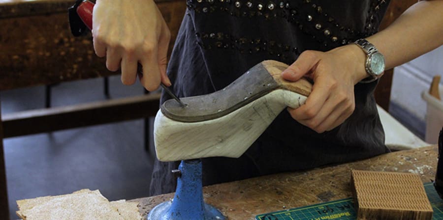 Person carving the sole of a shoe