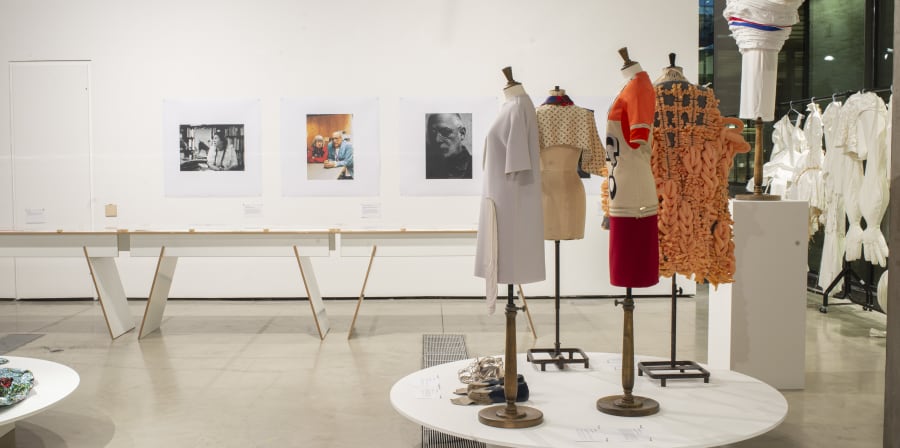 exhibition with mannequins and portrait photos on back wall