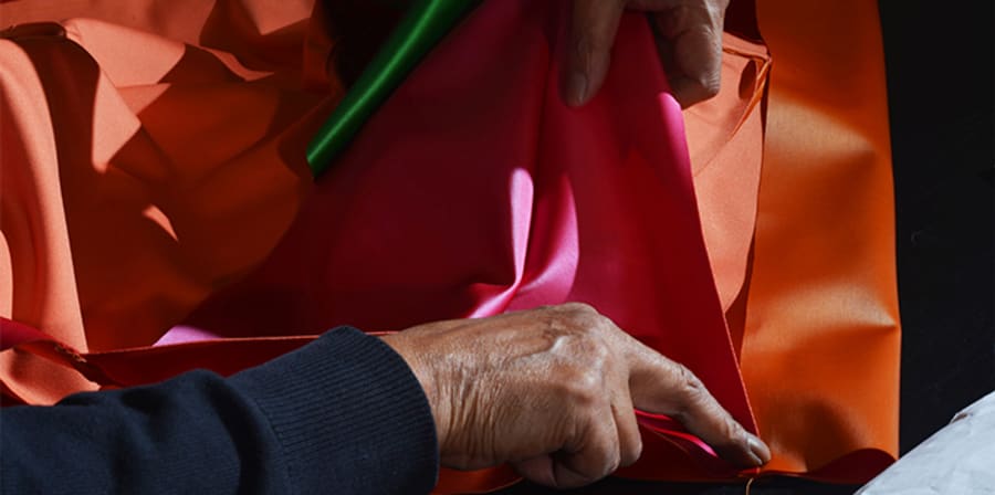 A pair of hands holding brightly coloured fabric