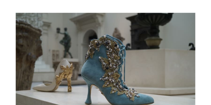 An ankle boot in turquoise suede with gold baroque column detailing on the heel