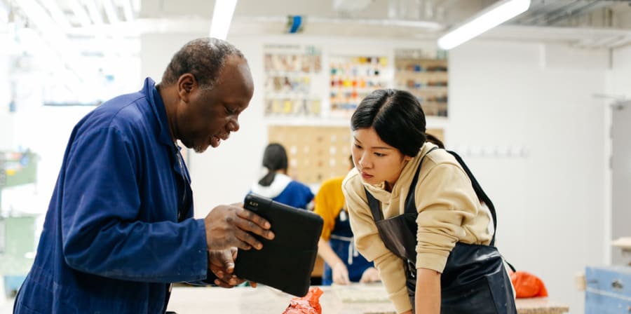 Technician and student conferring over a workbench