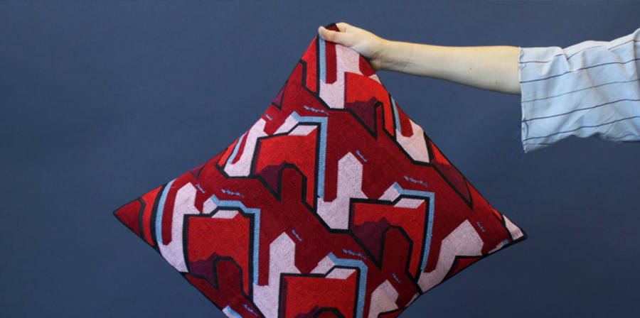 Hand holding a red patterned cushion