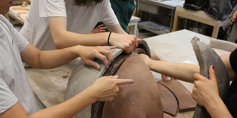 Pairs of hands working on a model