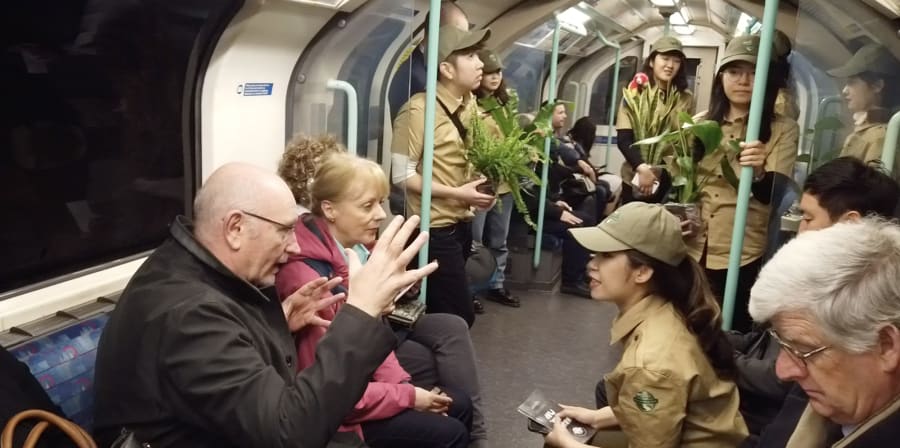 Students dressed as park rangers engage the travelling public in converesation on a tube train