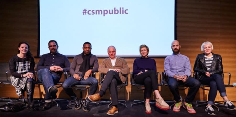 Group of people sitting in a row on a stage