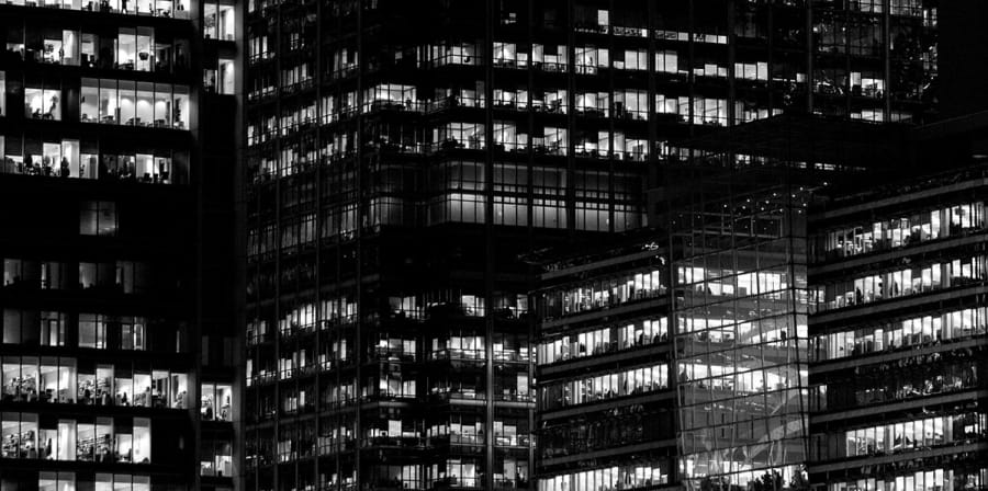 A black and white photograph of skyscrapers lit up at night.