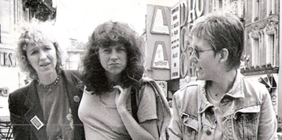 Black and white photo of Lindsay Cooper with two woman walking down a street.