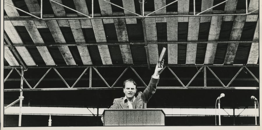 Black and white photograph, portrait person speaking at podium